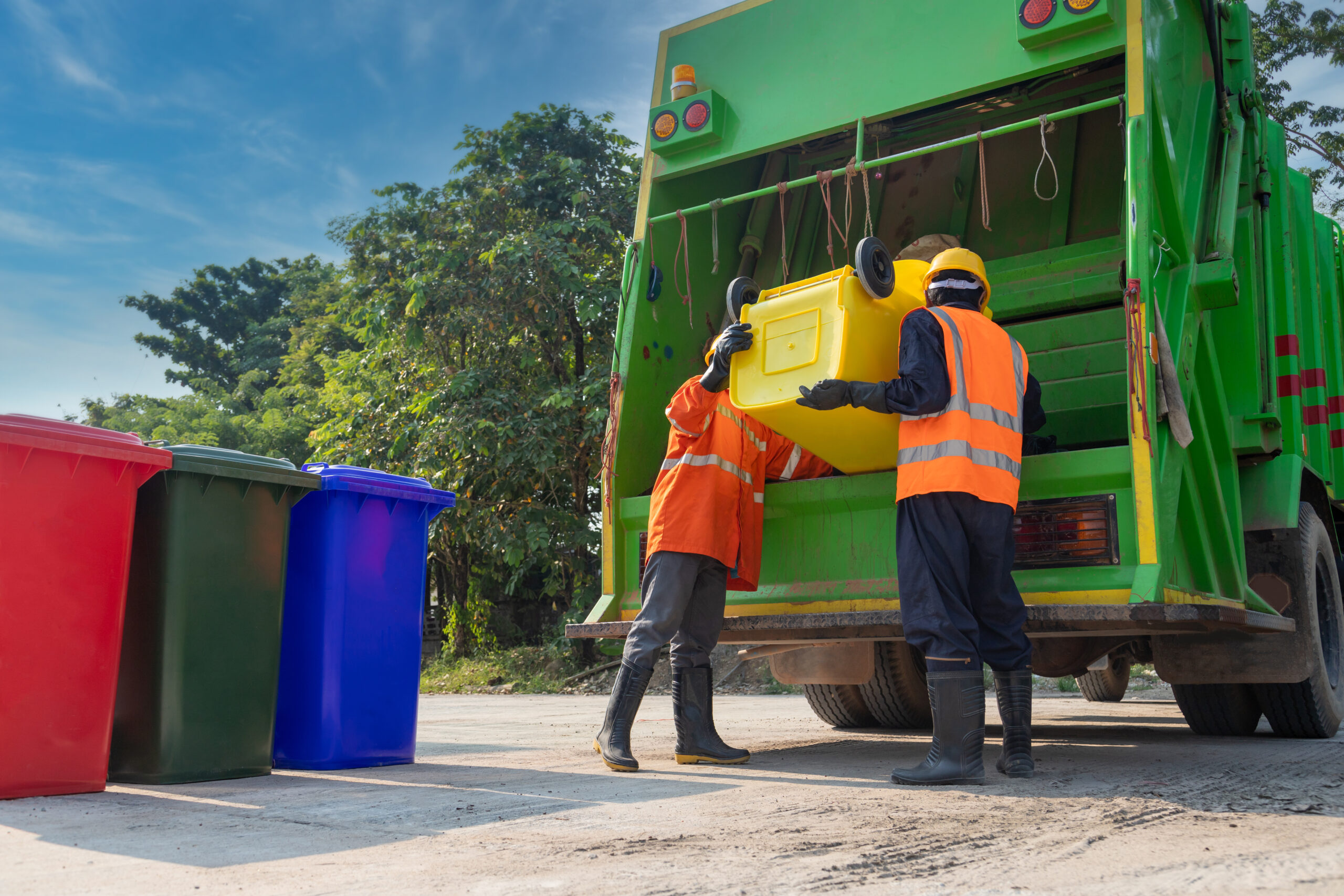 Teamwork garbage men working together on emptying dustbins for t